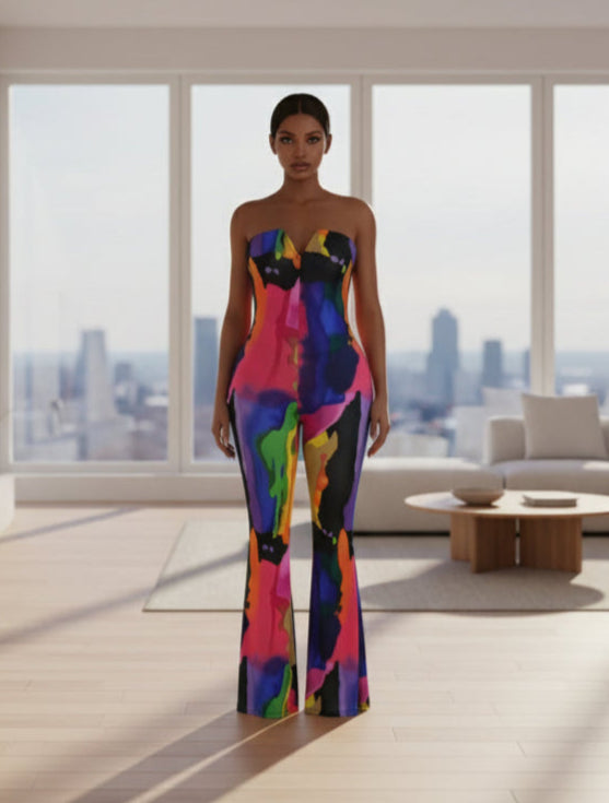 Person wearing a colorful strapless jumpsuit in a modern living room with large windows.